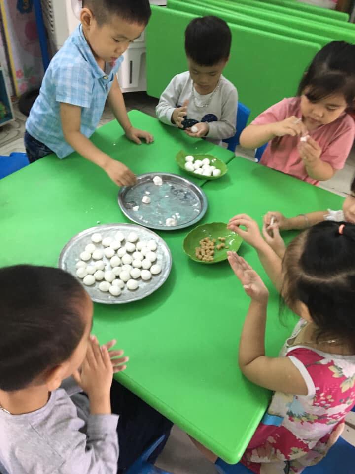 Các bé mẫu giáo 4 tuổi đang nặn bánh trôi